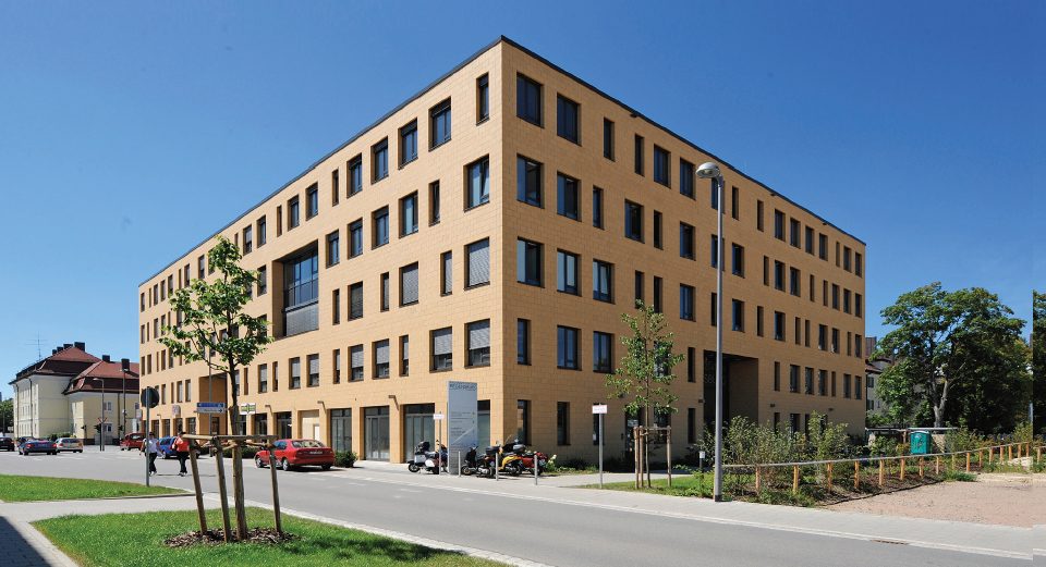 The photo shows a contemporary office building in Regensburg, Germany