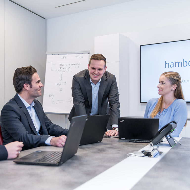 Das Foto zeigt die zufriedenen Mitarbeiter der Hamborner Reit AG in einem Meeting