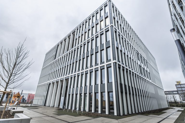 The photo displays an office building in Münster. Its modern facade stands out in comparison with the other buildings in the area.